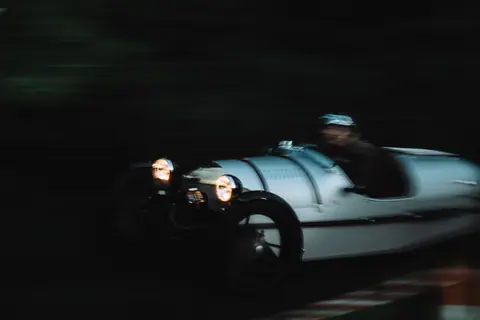 Dynamic shot of a classic sports car racing, showcasing blurred motion and vintage charm.