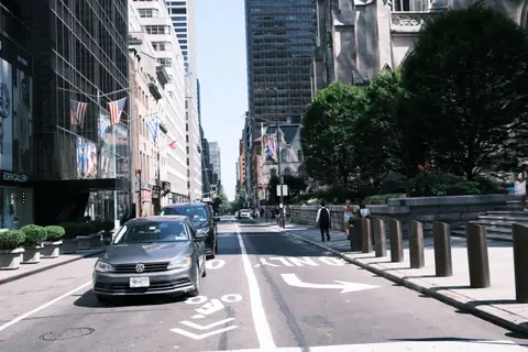 View of a busy street in New York City with cars and pedestrians on a sunny day.