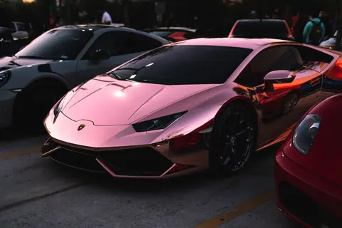 Sleek rose gold Lamborghini shining at an outdoor car show, epitome of luxury and power.