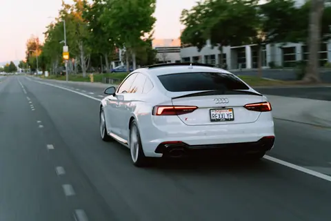 A white Audi captures motion on a city road during a serene evening drive.