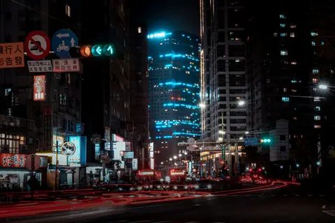 Dynamic night scene of Taipei's urban landscape with light trails and vibrant skyscrapers.