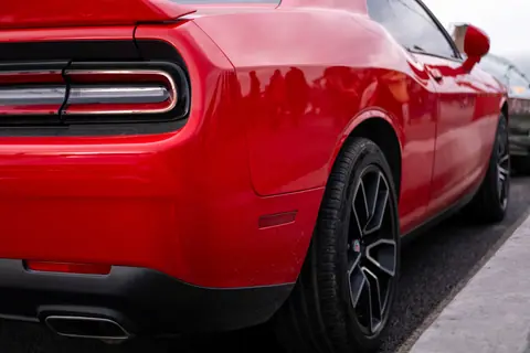 Close-up of a red sports car highlighting its taillight and sleek design.