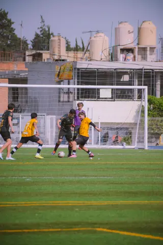 Young players competing in a soccer match on an outdoor turf field, showcasing teamwork and energy.