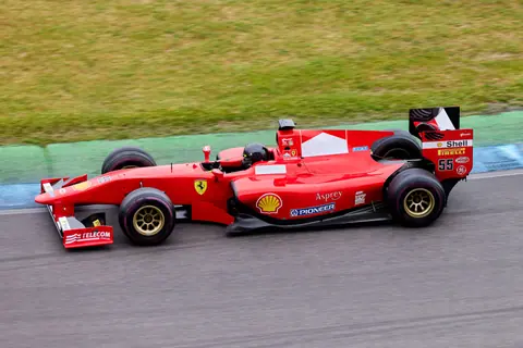 High-speed Formula 1 car in action on an outdoor racing track, showcasing motion and excitement.