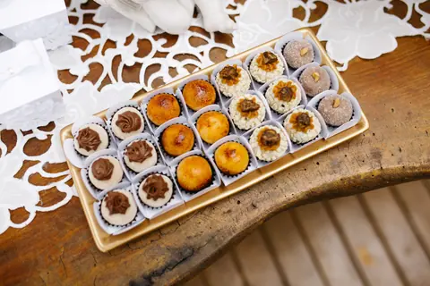 A selection of gourmet pastries displayed on a rustic wooden table with lace decor.
