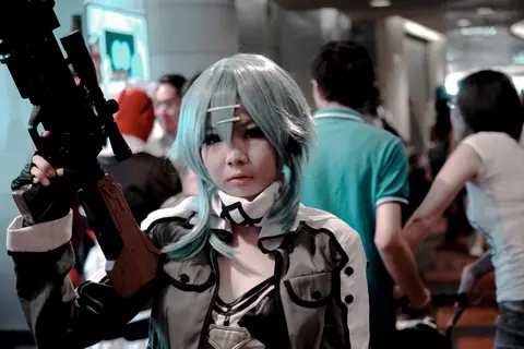 Vibrant cosplay participant posing indoors at a bustling convention scene.
