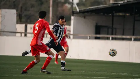 Two soccer players in action on the field, competing intensely during a match.