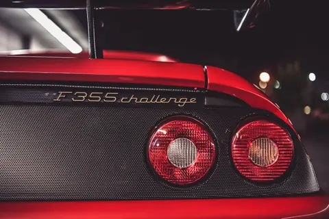 Detailed view of a Ferrari F355 Challenge taillight showcasing luxury design at night.