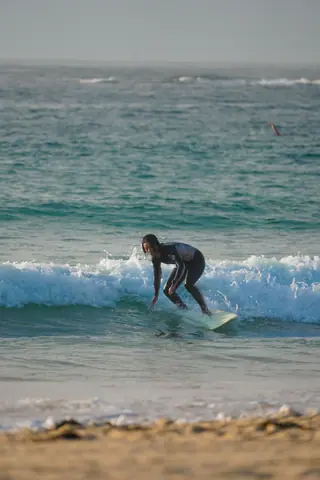 Surfer catching a wave on a sunny day at the beach. Energetic and adventurous.