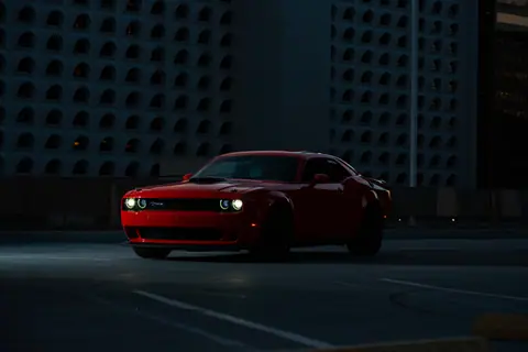 A sleek red sports car parked in an urban setting at night, exuding luxury and style.