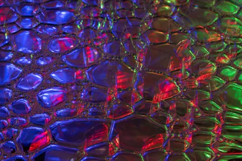Colorful iridescent bubble texture with neon shades, creating a vibrant abstract pattern.