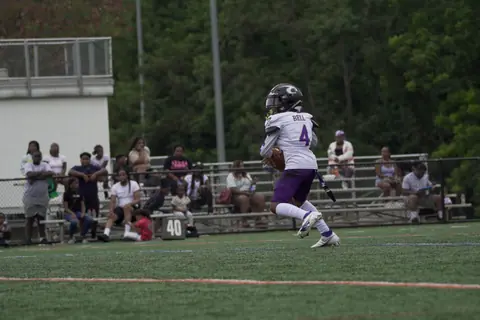 A young athlete runs on a football field during a game in Columbia, MD.