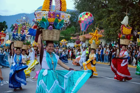 Vibrant street parade featuring women in traditional costumes, celebrating cultural heritage.