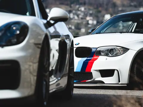 Close-up view of luxury sports cars parked outdoors, showcasing sleek designs and vibrant colors.
