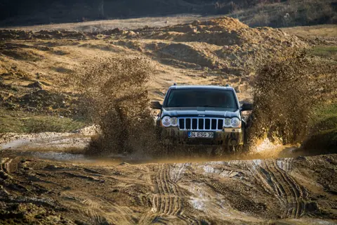 A jeep navigates through a muddy puddle, showcasing off-road adventure in İstanbul, Türkiye.
