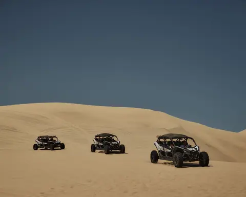 Explore thrilling off-road adventures across vast desert dunes under a clear blue sky.