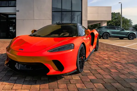 A vibrant red sports car parked in front of a modern building, epitomizing urban luxury.