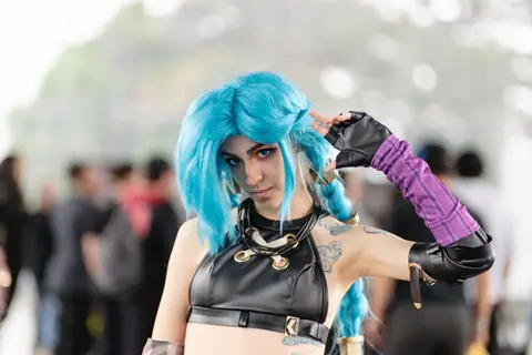 Colorful anime cosplay showcasing character with blue hair at San José event.