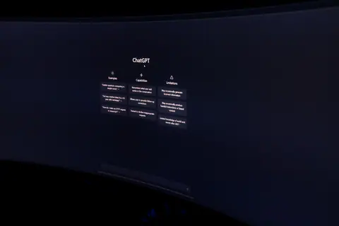 A dark, minimalist photo of a computer monitor displaying the ChatGPT interface.