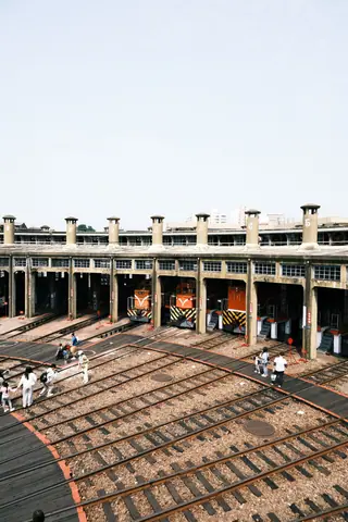 Historic railway roundhouse with trains and visitors in Changhua County, Taiwan.
