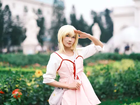 Cosplay enthusiast in a vibrant garden setting, showcasing anime-inspired fashion with a playful salute.
