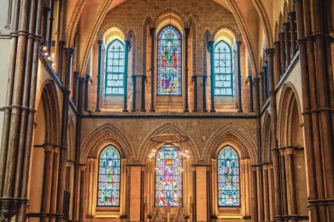 Stunning view of a Gothic cathedral interior showcasing ornate stained glass windows and arches.