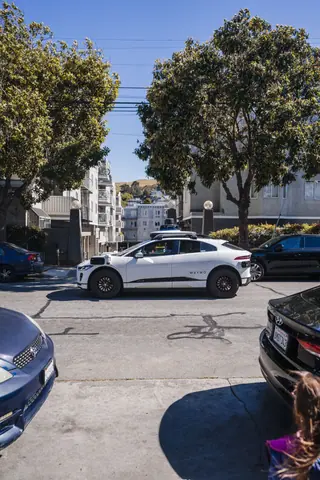 A self-driving car traveling through a residential area in San Francisco on a sunny day.