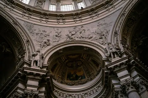 Stunning view of a richly decorated Baroque ceiling with sculptures and detailed ornamentation.