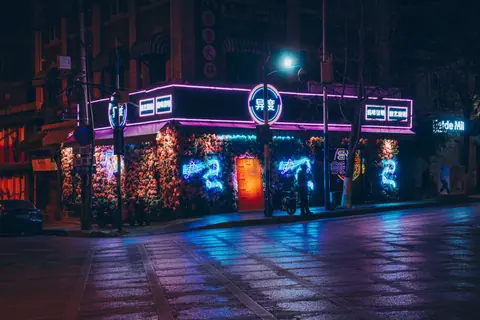 A captivating neon-lit street corner featuring vibrant decorations and urban nightlife.