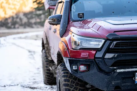 Close-up of a rugged off-road vehicle in snowy conditions, perfect for adventure enthusiasts.
