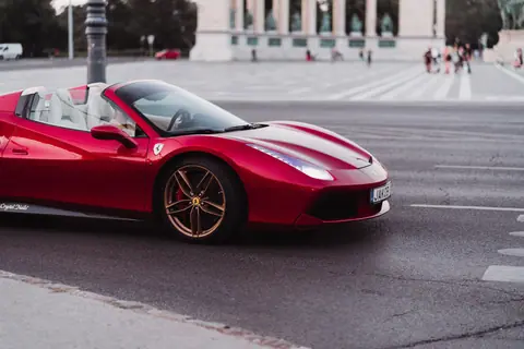 A stunning red Ferrari supercar captured on a city street, showcasing sophistication and speed.