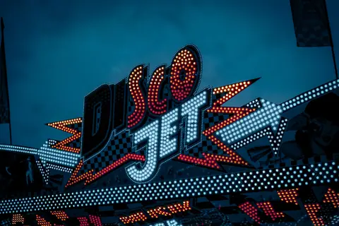 A dazzling Disco Jet neon sign glowing brightly in the night.