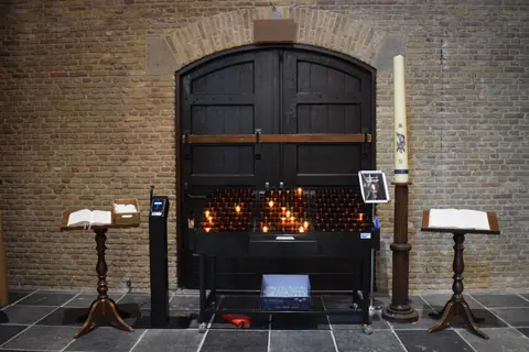 A serene church setting with lit candles, open prayer books, and traditional wooden furniture.