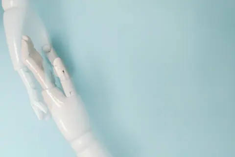 Two robotic hands on a blue background representing technology and innovation.