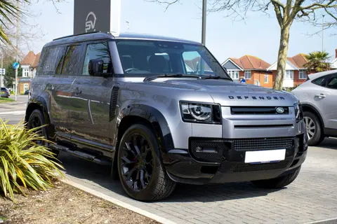 A modern gray Land Rover Defender parked on an urban street in Christchurch, England, showcasing its rugged elegance.