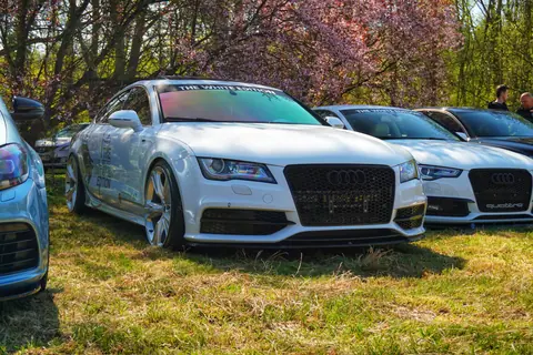 High-performance luxury cars exhibited outdoors during a sunny auto show.