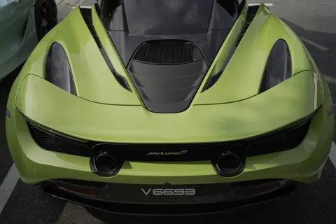 Close-up of a sleek green McLaren sports car showcasing its aerodynamic design.