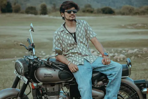Stylish young man posing on a Royal Enfield motorcycle in Salem, India.