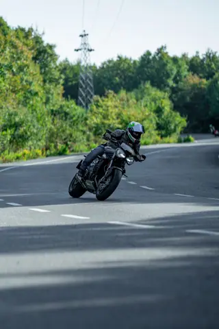 Dynamic shot of a motorcyclist leaning into a curve on a scenic mountain road, showcasing speed and agility.