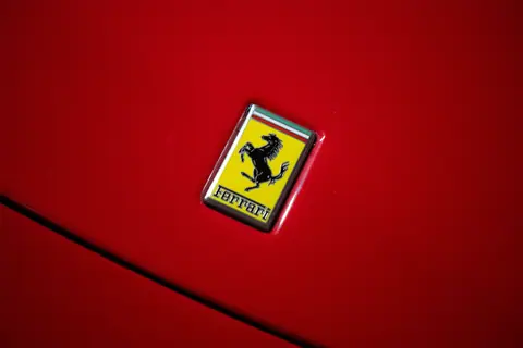 Bright red Ferrari with the iconic prancing horse emblem close-up.