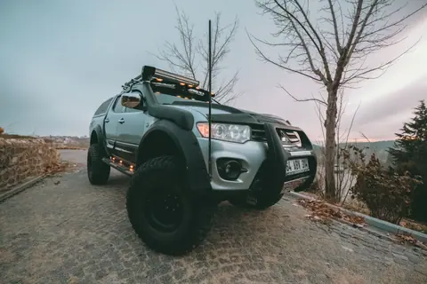 4x4 SUV parked on a paved hill with a scenic dusk backdrop.