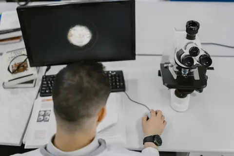 Scientist working with a microscope in a modern laboratory setup.