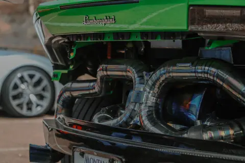 Close-up image of a Lamborghini supercar's exposed exhaust pipes.