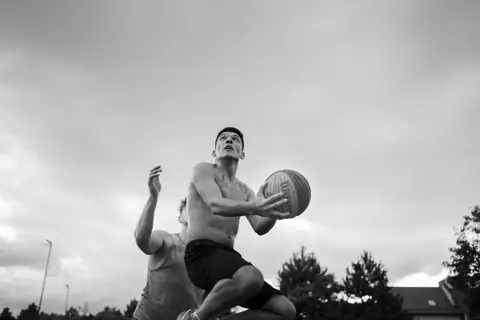 Intense black and white shot of athletes in motion during a basketball game outdoors in Cluj-Napoca.