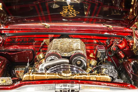 Detailed view of a custom lowrider engine at a New York auto show featuring ornate designs.