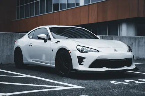 A sleek white sports car parked in an urban setting, showcasing modern design and style.