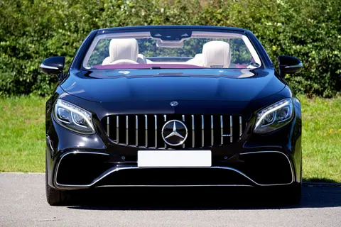 Front view of a sleek black Mercedes-Benz convertible parked on a sunny day.