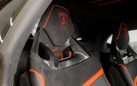 Luxurious interior of a Lamborghini sports car featuring sleek carbon fiber seats.