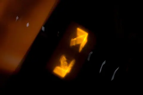Dynamic abstract image of blurred orange and yellow light streaks in a dark setting.