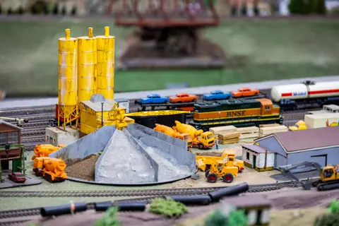 Detailed miniature train set featuring construction vehicles and industrial setup with a BNSF train.
